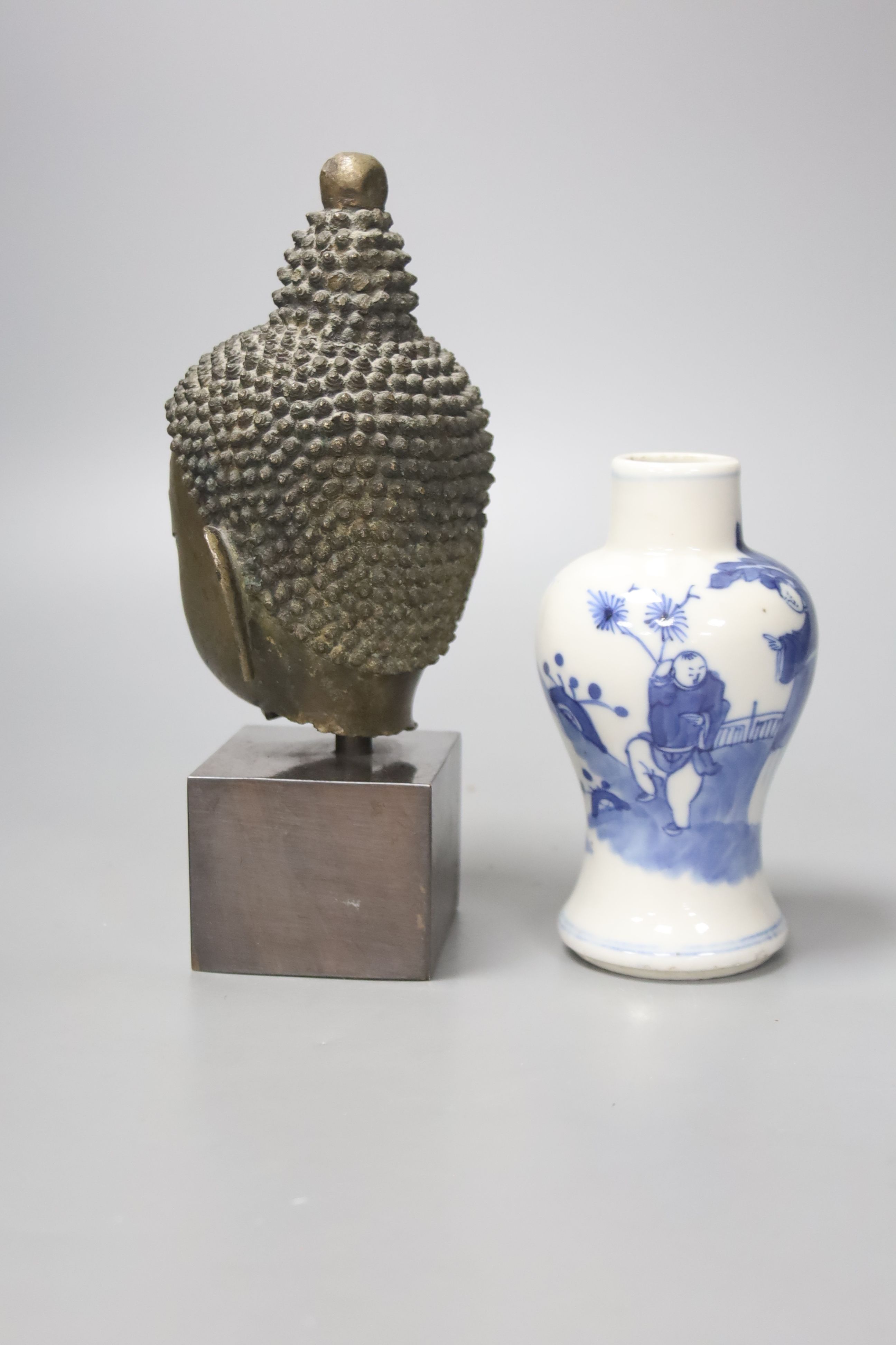 A Thai or Burmese bronze Buddha’s head, with stand 20.5cm and a 19th century Chinese blue and white vase, 12.5cm